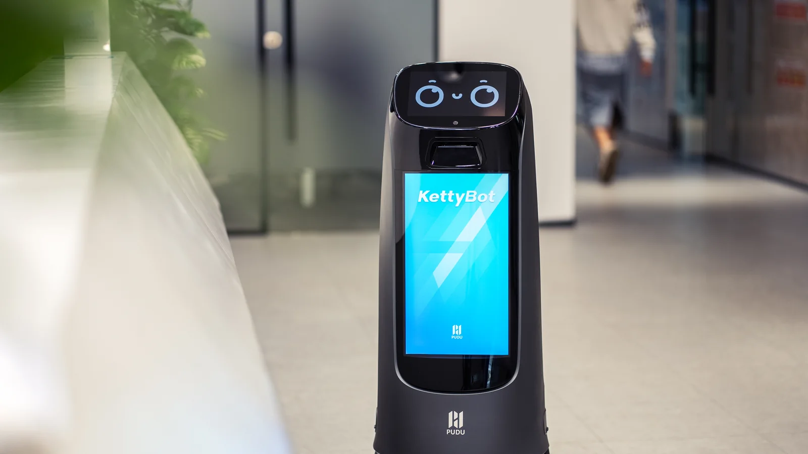 KettyBot Pro delivering along a glass walled corridor
